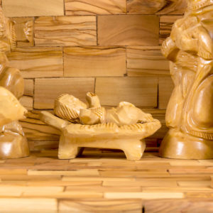 a wooden navity scene with baby Jesus in a manger